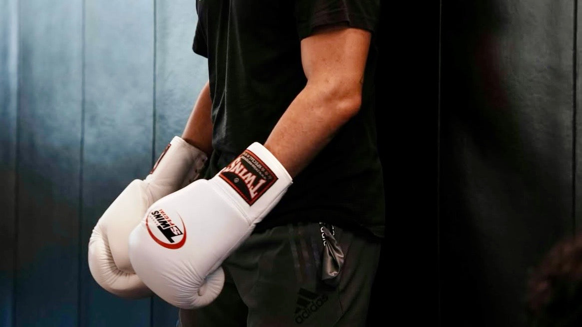 Boxer mit weissen Twins-Special-Handschuhen, verschränkte Arme